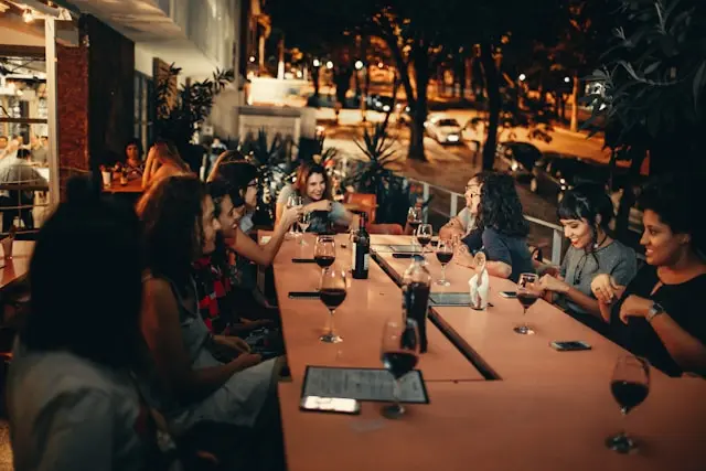 A Woman Drinking Wine and Sitting on a Bar Table you can find on Gecko