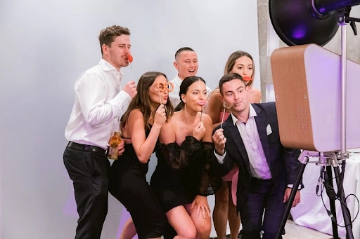 An image of people standing infront of a photo booth.